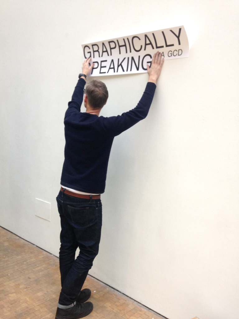 Dan preparing to stick some vinyl cut text onto the wall
