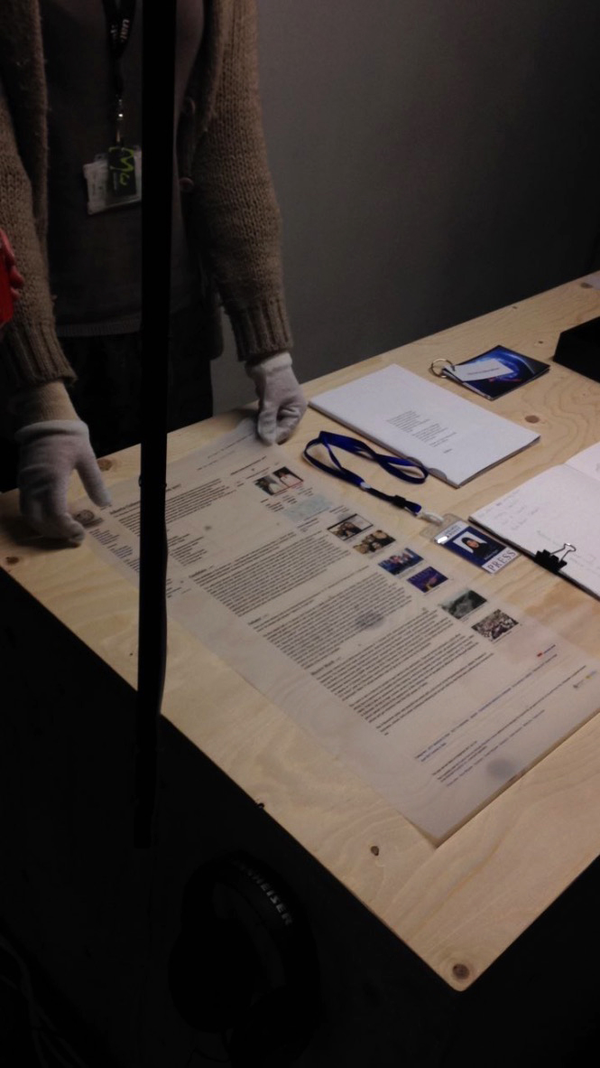 A person wearing white gloves preparing items for the exhibition